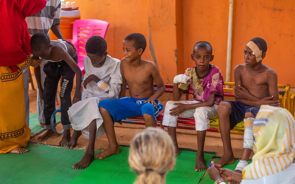 Verletzte Kinder im Sudan | © UNICEF/UNI626278/Isamaldeen Mehrere Jungen auf einer Bank, einige von ihnen mit Verbänden