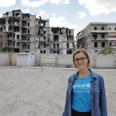 Ninja Charbonneau, Sprecherin von UNICEF Deutschland | © UNICEF/UNI883550/Ashawi Ninja Charbonneau, Sprecherin von UNICEF Deutschland vor zerstörten Häusern in Syrien