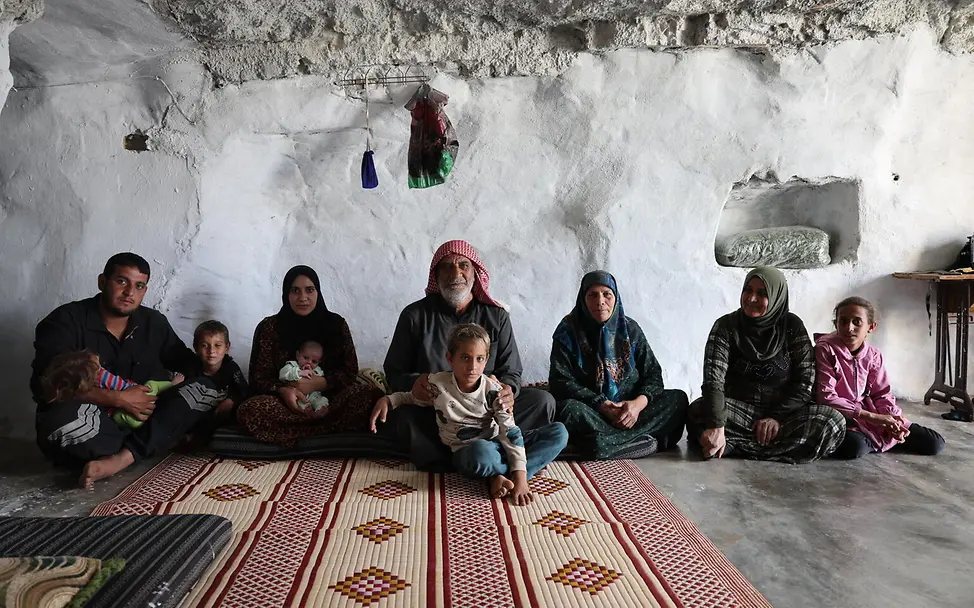 Eine Familie in Syrien | © UNICEF/UNI883463/Ashawi eine Familie sitzt auf dem Boden einer Höhle in der sie lebt