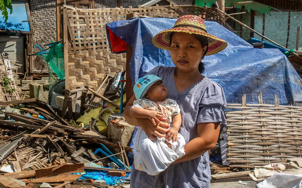 Mutter mit Baby vor Trümmern | © UNICEF/UNI869112/Htet Eine Mutter mit Baby im Arm